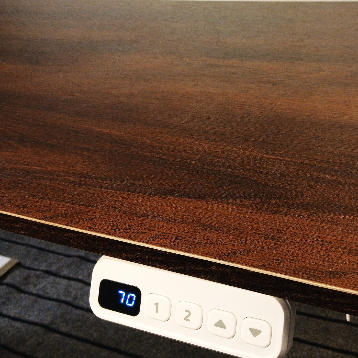 Electric standing desk with dark brown textured tabletop
