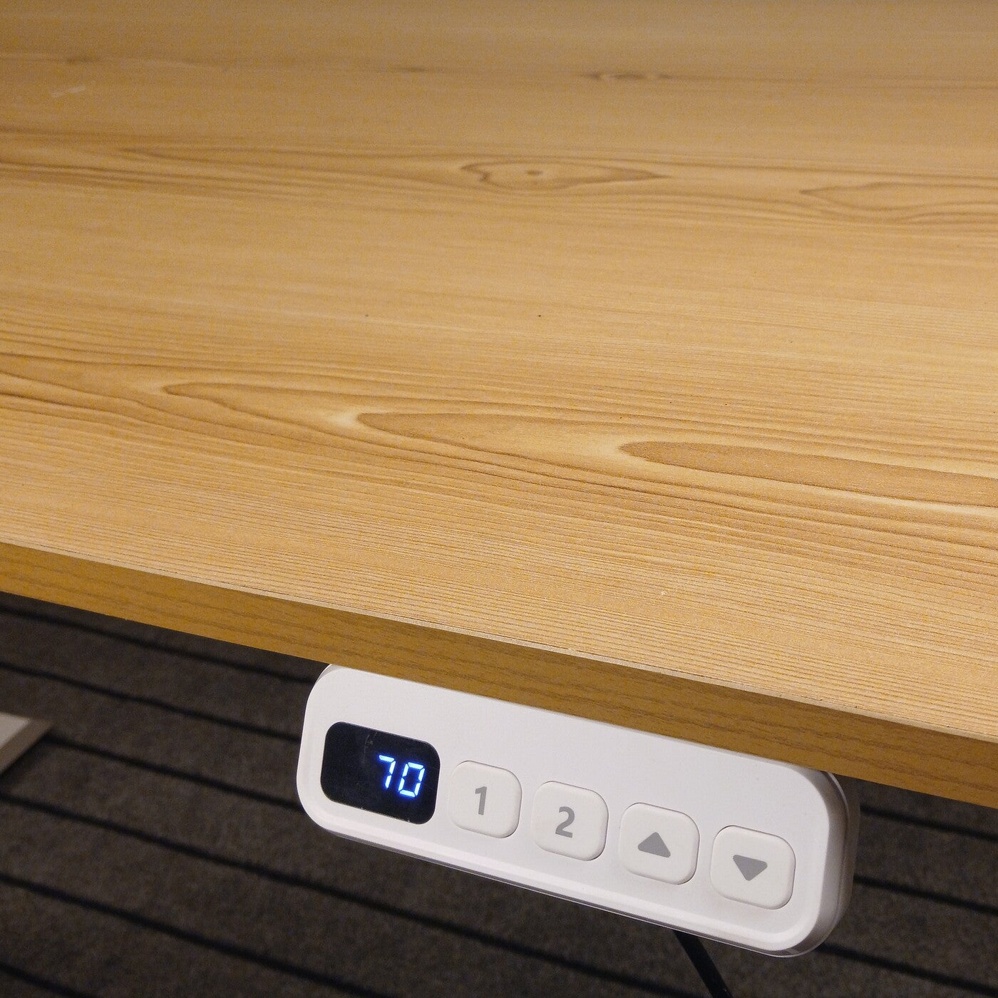 Electric standing desk with light brown laminated tabletop